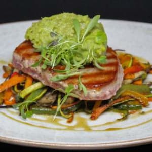 Atún con quenelle de quinoa con palta y vegetales al wok. / Grilled tuna with quinoa and avocado quenelle and sauteed vegetables.