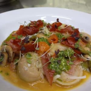 Agnolotti de calabaza y almendra, salteados con champignones, esparragos, tomate cherry y crocancia de prosciutto. / Pumpkin and almond ravioli.